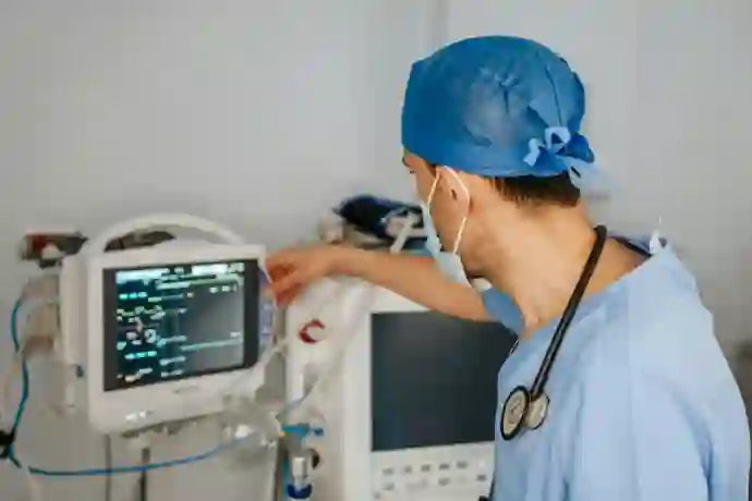 a man in scrubs and a stethoscope looking at a monitor inside hospital