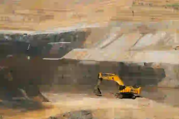 a yellow excavator in mine field of west bengal