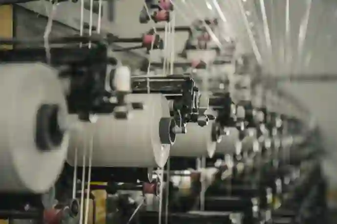 a row of machines that are next to each other in a textile factory to convert  raw fabrics into finished yarns